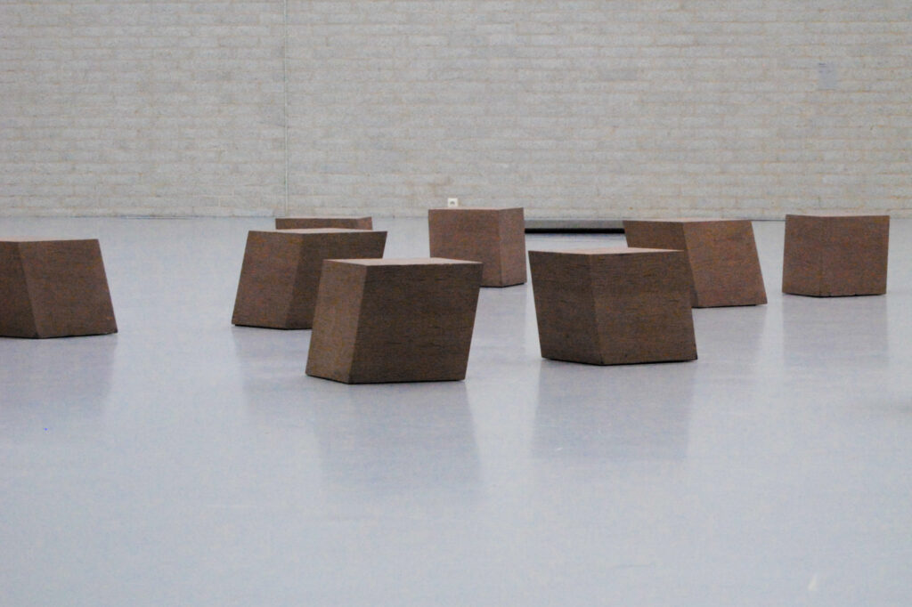 A Cast of the space under my chair, Bruce Naumann (Kröller-Müller Museum, Otterlo) (2015). auf dem glatten weißen Boden stehen schräg gekippte Betonklötze.
